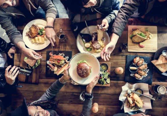 people sitting around a table eating food