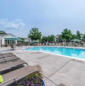 A pool area with a sun lounger and a pool.