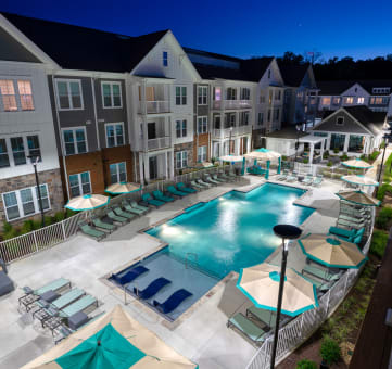 an aerial view of the resort style pool with chaise lounge chairs and umbrellas at Artistry at Winterfield Apartments, Virginia