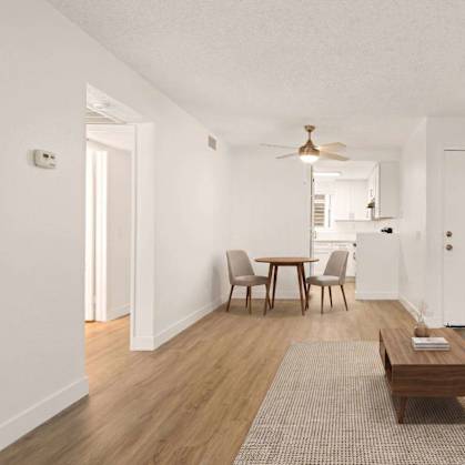 A living room with a grey couch, a wooden coffee table, and a ceiling fan.