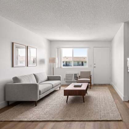 A modern living room with a grey sofa and a coffee table.