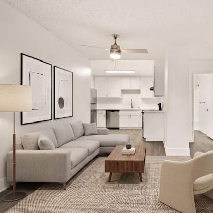 A modern living room with a grey sofa, a wooden coffee table, and a beige armchair.