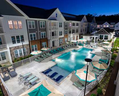an aerial view of the resort style pool with chaise lounge chairs and umbrellas at Artistry at Winterfield Apartments, Virginia