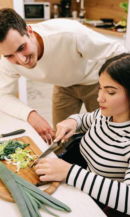 A man and a woman are preparing a salad together.