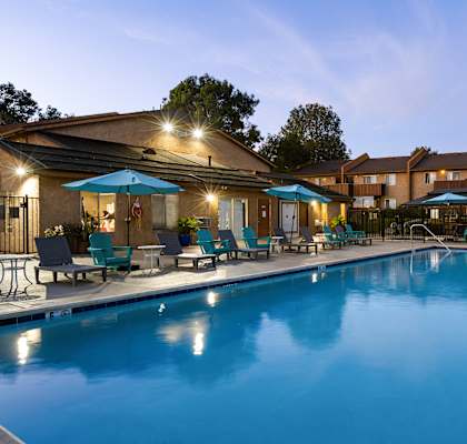 A large swimming pool surrounded by lounge chairs and umbrellas.
