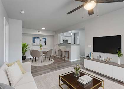 A modern living room with a white couch, a coffee table, and a flat-screen TV.