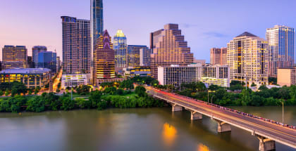a view of the austin skyline at dusk with a bridge in the foreground