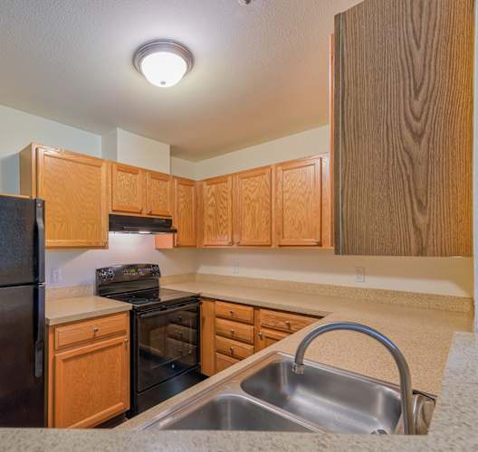 an empty kitchen with a sink and a refrigerator