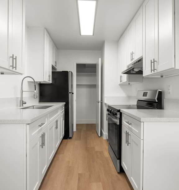 A modern kitchen with a stainless steel refrigerator and a white countertop.