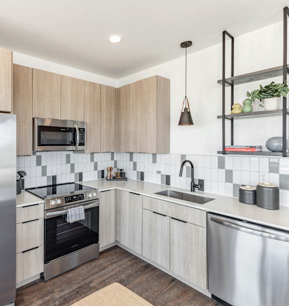 A modern kitchen with stainless steel appliances and wooden cabinets at Anthem House Apartment, Huntsville, AL, 35806