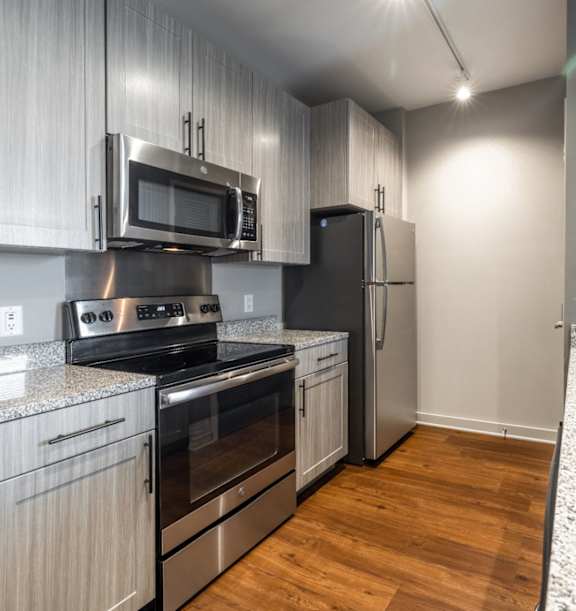 a kitchen with a marble counter top and a stainless steel refrigerator at The Beck at Hidden River, Tampa, FL, 33637