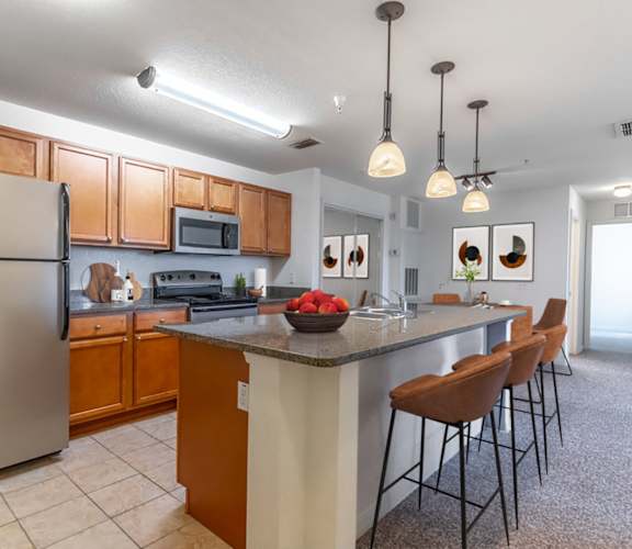 a kitchen with a large island and stainless steel appliances