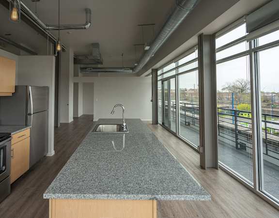 A kitchen with a granite countertop and stainless steel appliances.