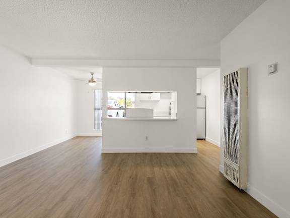 A kitchen with a table and chairs in front of a fridge and cabinets.