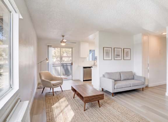 A living room with a chair, a couch, and a coffee table.