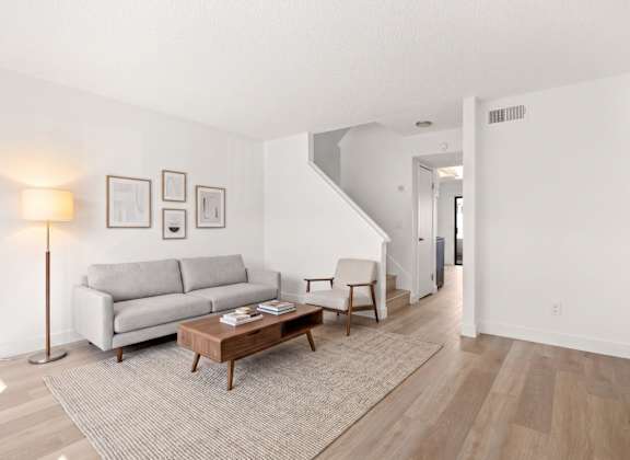 A living room with a grey couch and a wooden coffee table.