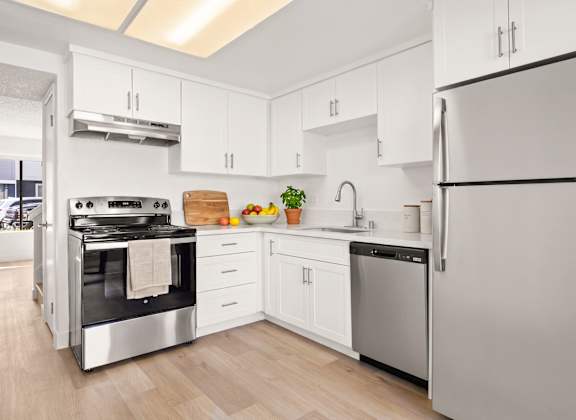 A modern kitchen with a stainless steel refrigerator and oven.