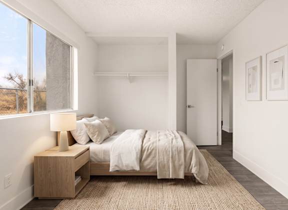 A bedroom with a bed, nightstand, and two pictures on the wall.