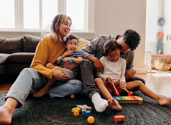 Family Sitting on Floor in Living Room Playing with Toys