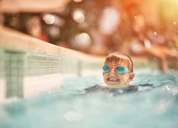 a boy in a swimming pool wearing blue goggles at Portofino Cove in Fort Myers