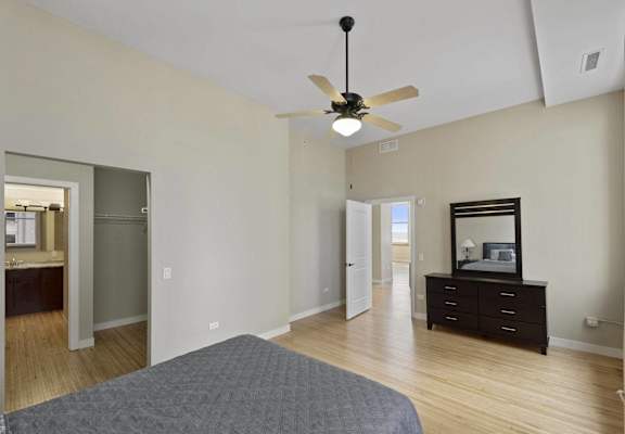 a bedroom with a bed and a ceiling fan