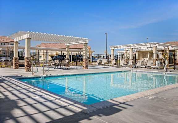 A large swimming pool with a sun shade over it.