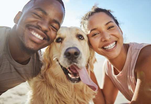 Man and Woman Smiling with Pet Dog