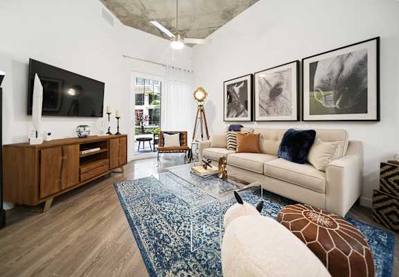 a living room with a white couch and a blue rug at Altis Grand Central Apartments in Tampa, FL