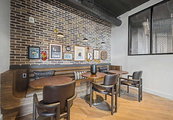 A room with a brick wall and a table with chairs.