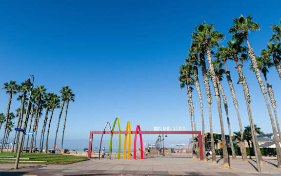 A McDonald's archway is framed by palm trees.