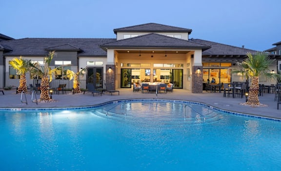 a swimming pool in front of a house with a resort style pool