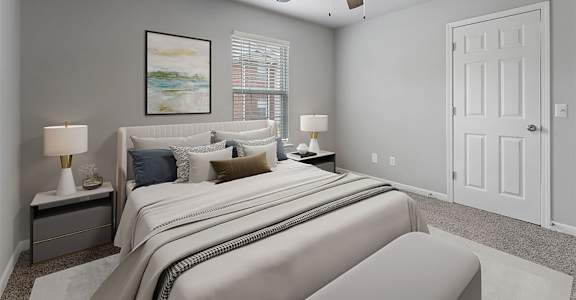 A bedroom with a large bed and a ceiling fan.