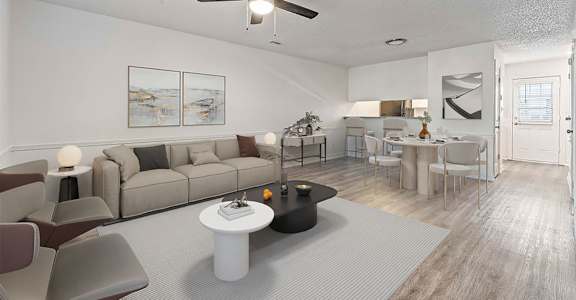 A living room with a grey couch, a white coffee table, and a ceiling fan.