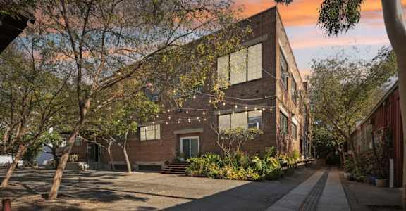 a brick house with a sidewalk in front of it