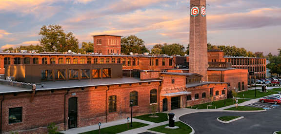 a building with a tall clock tower at sunset