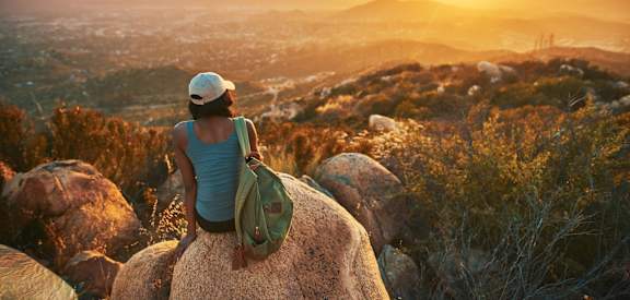 Woman on Hike Watching Beautiful Sunset
