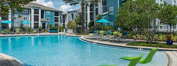A swimming pool in front of apartment buildings.