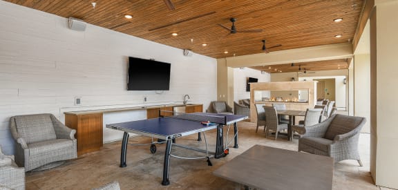 a room with a ping pong table and chairs  at Palm Bay Club, Jacksonville, 32258