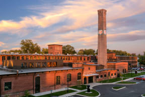 a building with a tall clock tower at sunset