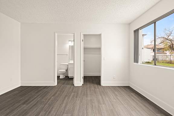 A room with a toilet and a bed in it.