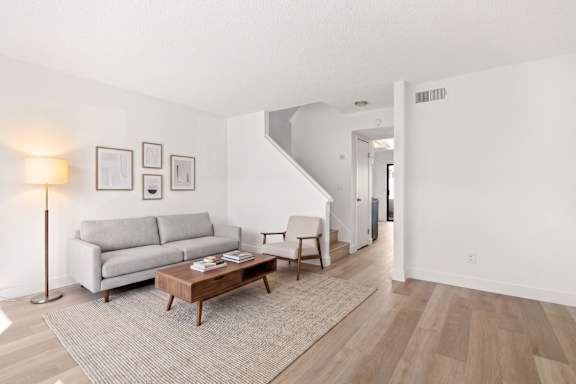 A living room with a grey couch and a wooden coffee table.