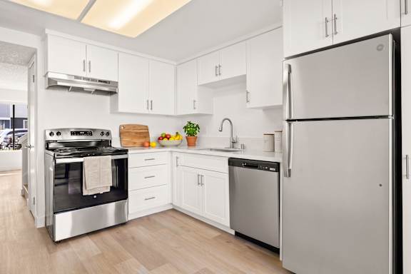 A modern kitchen with a stainless steel refrigerator and oven.