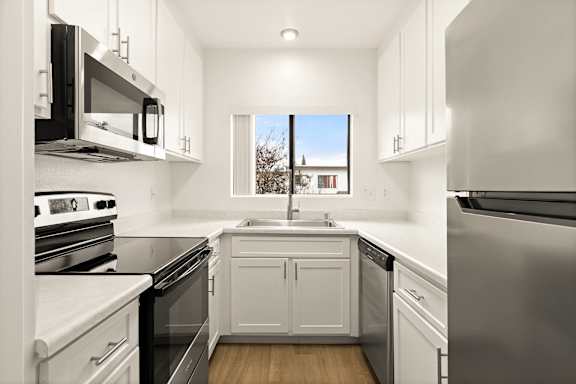 A modern kitchen with stainless steel appliances and white cabinets.