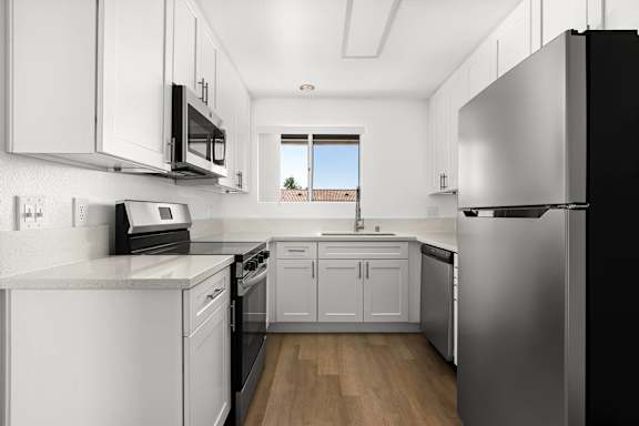 A modern kitchen with stainless steel appliances and white cabinets.
