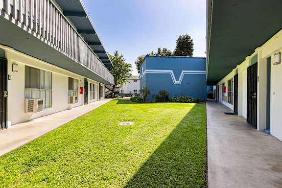 A long grassy area separates two buildings.