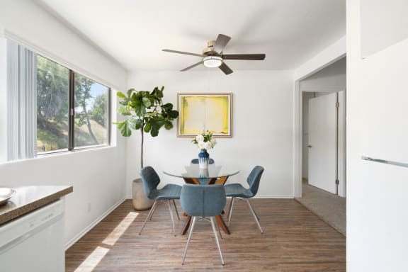 a dining room with a table and chairs and a ceiling fan