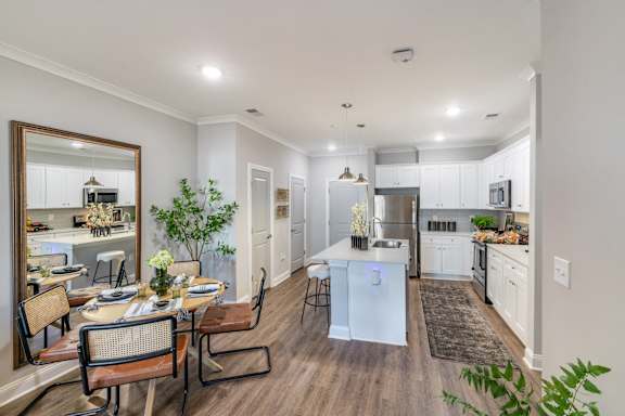 an open kitchen and living room with a dining room table and chairs