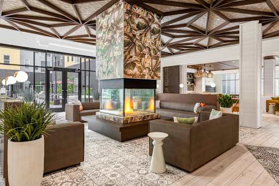 Community lobby with 360 degree fireplace at Stella Apartments in New Carrollton, MD