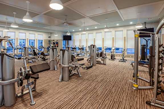 a spacious fitness center with cardio machines and weights