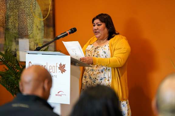 A woman is giving a speech at a podium.